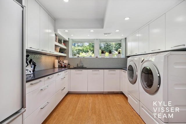 130 Robinwood Ave SE, Grand Rapids, MI 49506 - washroom featuring washer and clothes dryer, cabinet space, recessed lighting, and light wood-style flooring