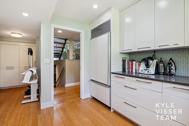 130 Robinwood Ave SE, Grand Rapids, MI 49506 - kitchen featuring paneled built in refrigerator, light wood-style flooring, backsplash, dark countertops, and recessed lighting