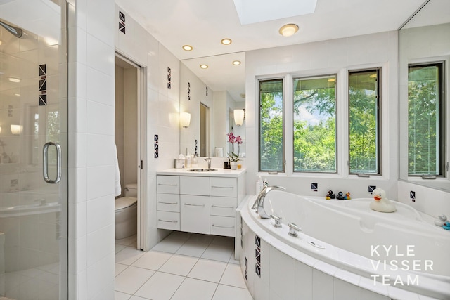 130 Robinwood Ave SE, Grand Rapids, MI 49506 - bathroom featuring a skylight, a stall shower, tile patterned flooring, vanity, and a bath