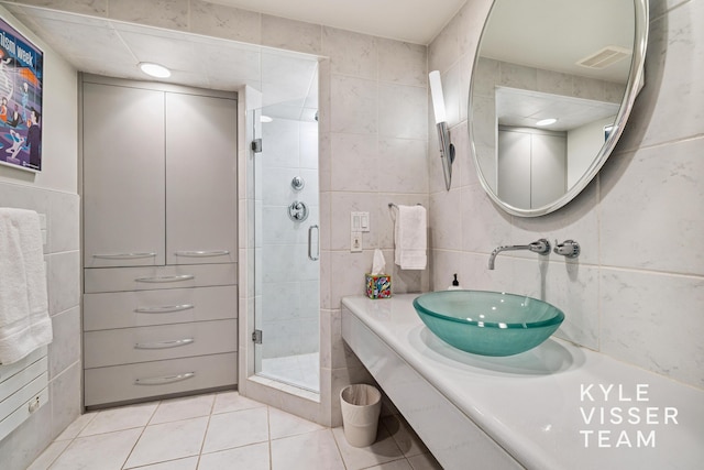 130 Robinwood Ave SE, Grand Rapids, MI 49506 - bathroom featuring tile walls, tile patterned flooring, a shower stall, and vanity