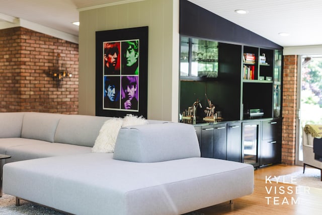 130 Robinwood Ave SE, Grand Rapids, MI 49506 - living area featuring beverage cooler, light wood-style floors, vaulted ceiling, brick wall, and recessed lighting