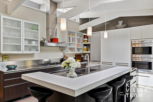 130 Robinwood Ave SE, Grand Rapids, MI 49506 - kitchen with appliances with stainless steel finishes, stainless steel countertops, a breakfast bar, range hood, and a kitchen island with sink