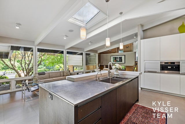 130 Robinwood Ave SE, Grand Rapids, MI 49506 - kitchen with open floor plan, a skylight, white cabinetry, and light tile patterned flooring