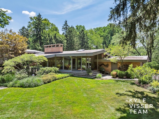 130 Robinwood Ave SE, Grand Rapids, MI 49506 - back of house with a yard and a sunroom