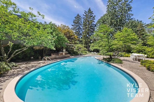 130 Robinwood Ave SE, Grand Rapids, MI 49506 - outdoor pool with a patio and view of scattered trees