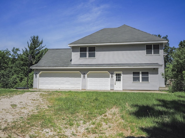 626 Skocelas Rd N, Manistee, MI 49660 - view of front facade with driveway, a front yard, and an attached garage
