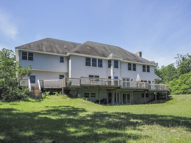626 Skocelas Rd N, Manistee, MI 49660 - back of house featuring a chimney, a wooden deck, and a lawn