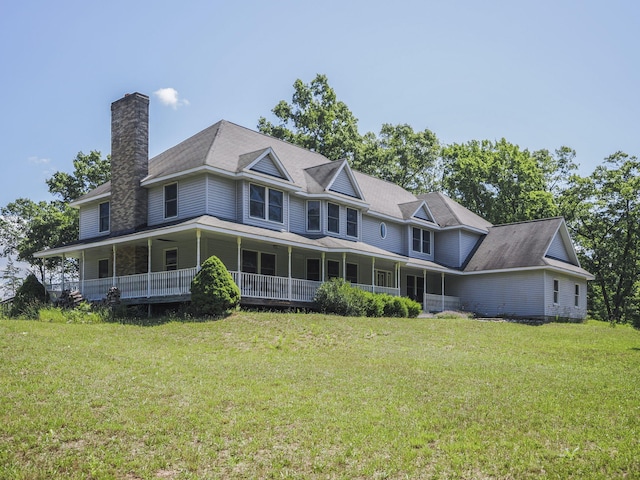 626 Skocelas Rd N, Manistee, MI 49660 - rear view of house with a chimney, a lawn, and a porch