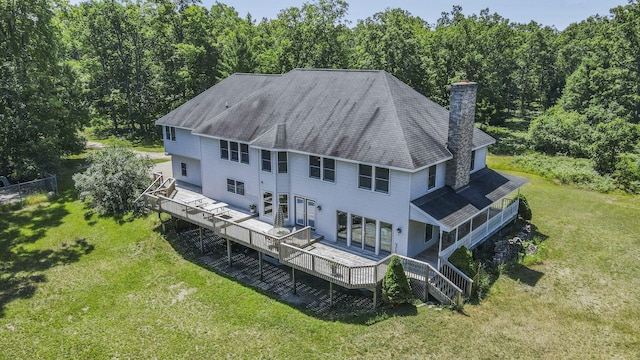 626 Skocelas Rd N, Manistee, MI 49660 - rear view of house with a chimney, a deck, a yard, and a forest view