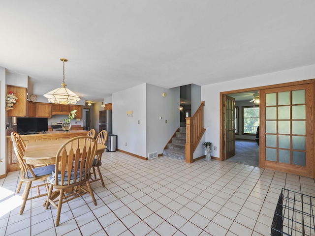 626 Skocelas Rd N, Manistee, MI 49660 - dining room with stairs, light tile patterned flooring, and a ceiling fan