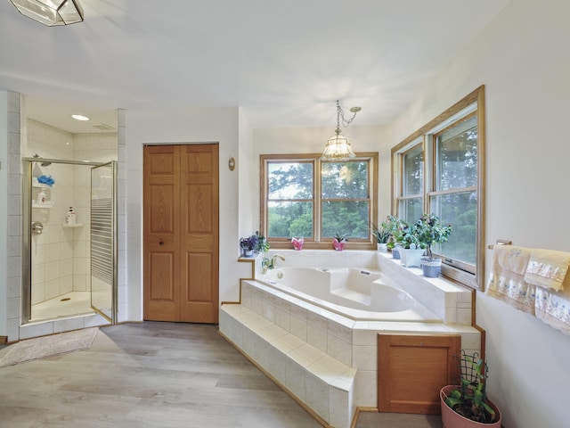 626 Skocelas Rd N, Manistee, MI 49660 - full bath featuring a bath, a shower stall, and wood finished floors