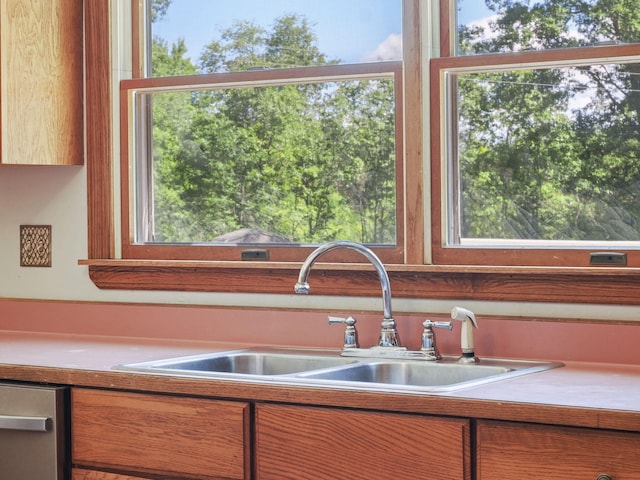 626 Skocelas Rd N, Manistee, MI 49660 - kitchen featuring brown cabinets, stainless steel dishwasher, and plenty of natural light