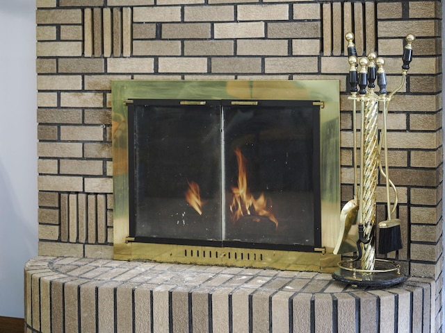 626 Skocelas Rd N, Manistee, MI 49660 - detailed view of a brick fireplace, radiator heating unit, and a chandelier