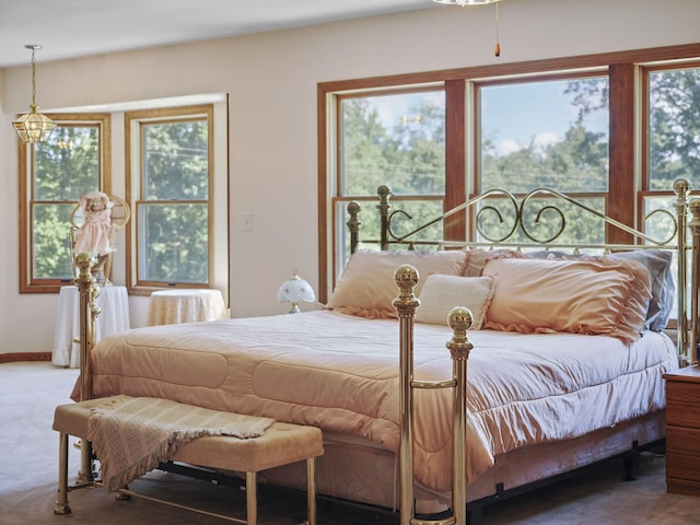 626 Skocelas Rd N, Manistee, MI 49660 - carpeted bedroom featuring multiple windows and a chandelier