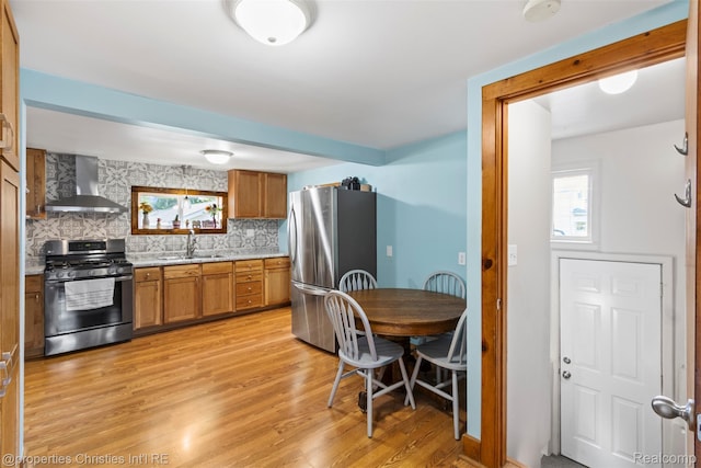 128 N Mary St, Marine City, MI 48039 - kitchen with wall chimney range hood, stainless steel appliances, brown cabinetry, light countertops, and tasteful backsplash