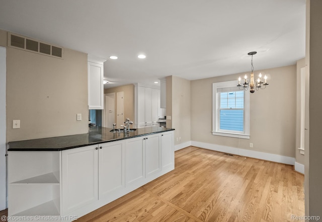 532 Wallace St, Southfield, MI 48009 - kitchen with white cabinetry, light wood finished floors, a chandelier, recessed lighting, and dark countertops