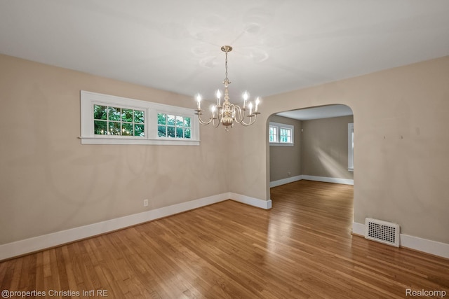 532 Wallace St, Southfield, MI 48009 - spare room with arched walkways, wood finished floors, and a chandelier