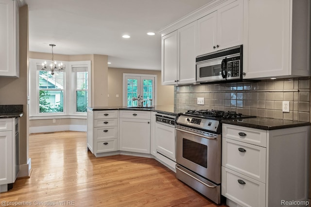 532 Wallace St, Southfield, MI 48009 - kitchen with stainless steel appliances, light wood-type flooring, white cabinets, a chandelier, and recessed lighting