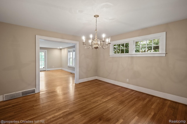 532 Wallace St, Southfield, MI 48009 - unfurnished room with a chandelier, wood finished floors, and plenty of natural light