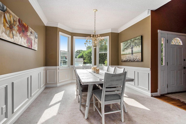4202 Courtney St, Saint Joseph, MI 49085 - dining area featuring a chandelier, light carpet, a decorative wall, ornamental molding, and a textured ceiling