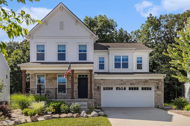 6217 S Trailwoods Dr, Ann Arbor, MI 48103 - view of front facade featuring stone siding, covered porch, board and batten siding, concrete driveway, and a garage