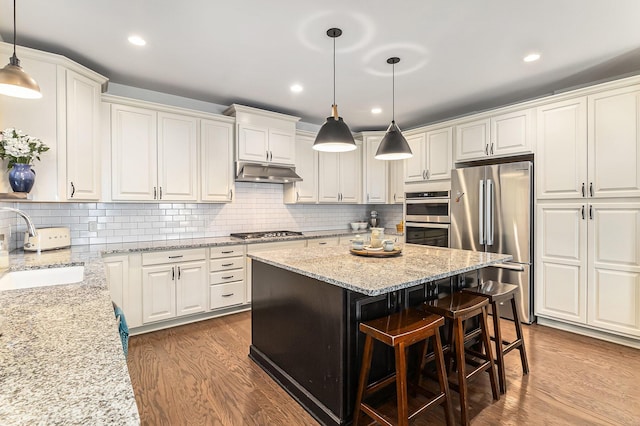 6217 S Trailwoods Dr, Ann Arbor, MI 48103 - kitchen featuring stainless steel appliances, dark wood finished floors, white cabinets, a kitchen island, and recessed lighting