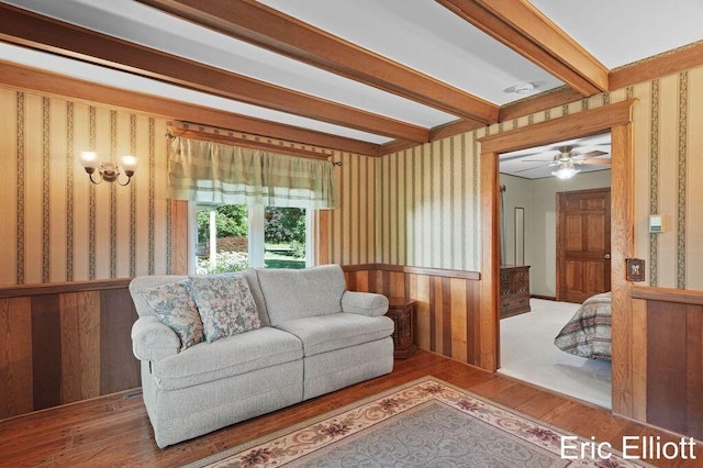 4305 76th St SW, Byron Center, MI 49315 - living room with wallpapered walls, hardwood / wood-style flooring, wainscoting, beamed ceiling, and ceiling fan