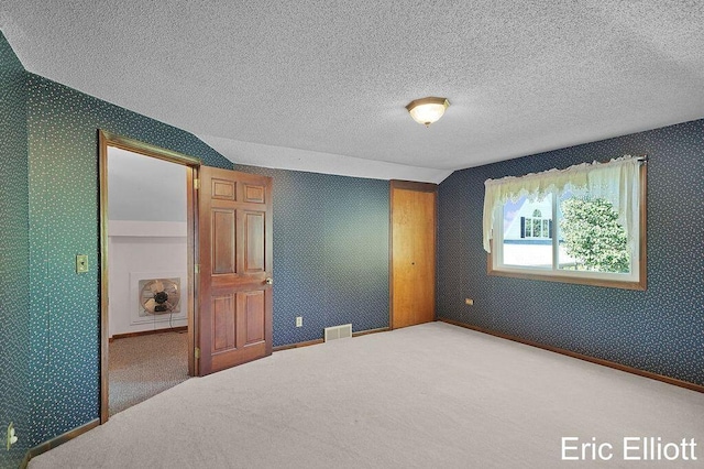 4305 76th St SW, Byron Center, MI 49315 - unfurnished bedroom featuring wallpapered walls, a textured ceiling, carpet floors, and a closet