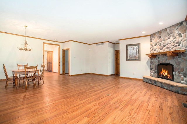 11463 Snowshoe Dr, Plainwell, MI 49080 - living area featuring a chandelier, a stone fireplace, light wood-style flooring, crown molding, and recessed lighting