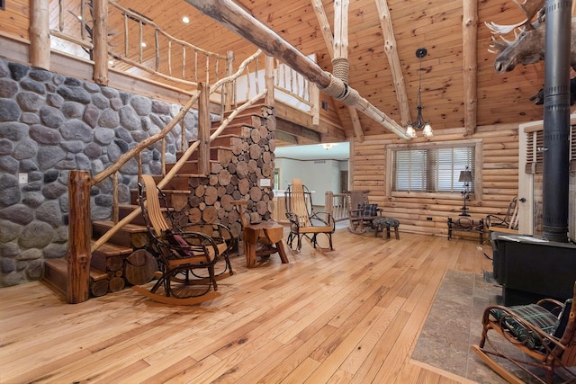 11463 Snowshoe Dr, Plainwell, MI 49080 - living room featuring rustic walls, high vaulted ceiling, hardwood / wood-style flooring, a wooden ceiling with exposed beams, and a wood stove