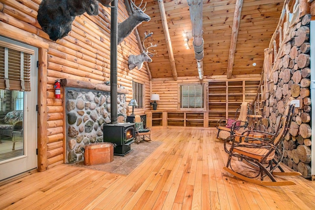 11463 Snowshoe Dr, Plainwell, MI 49080 - unfurnished room featuring rustic walls, a wood stove, hardwood / wood-style flooring, high vaulted ceiling, and a wood ceiling with exposed beams