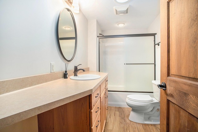 11463 Snowshoe Dr, Plainwell, MI 49080 - bathroom featuring vanity, wood finished floors, and combined bath / shower with glass door