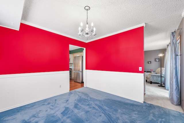 18165 Shamrock Blvd, Big Rapids, MI 49307 - carpeted spare room featuring a chandelier, a wainscoted wall, a textured ceiling, and ornamental molding