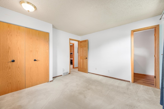 18165 Shamrock Blvd, Big Rapids, MI 49307 - unfurnished bedroom featuring carpet flooring, a closet, and a textured ceiling
