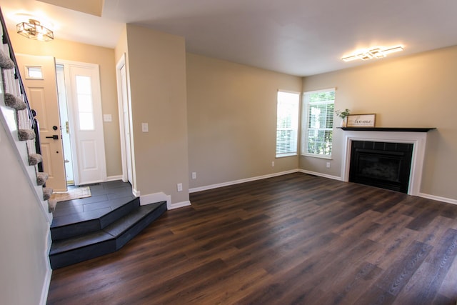 3216 E Morgan Creek Ct, Indiana, IN 46385 - unfurnished living room featuring dark wood finished floors, a fireplace, and stairs