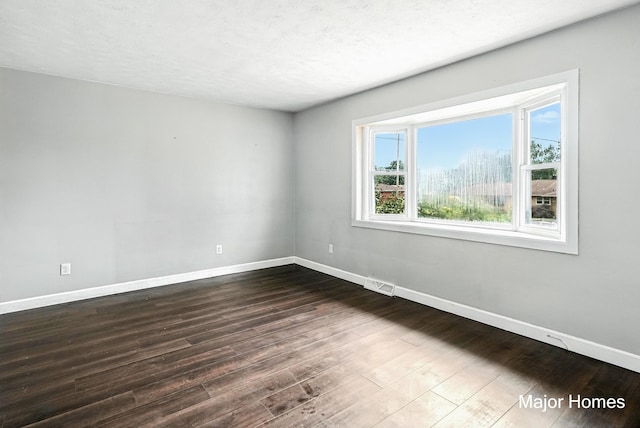 1435 Sweet St NE, Grand Rapids, MI 49505 - unfurnished room featuring baseboards and dark wood-style flooring