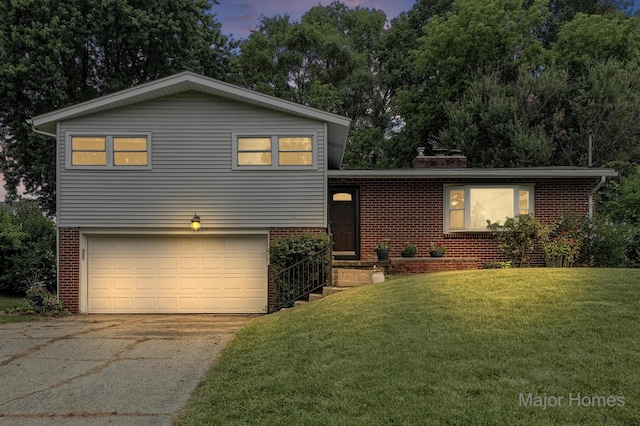 1435 Sweet St NE, Grand Rapids, MI 49505 - tri-level home with brick siding, an attached garage, a yard, and concrete driveway
