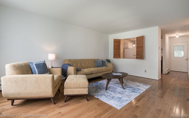 5959 Alan Dr # 56, Brighton, MI 48116 - living area featuring light wood finished floors and a baseboard radiator
