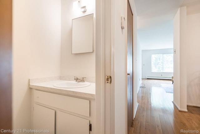 5959 Alan Dr # 56, Brighton, MI 48116 - bathroom featuring vanity, wood finished floors, and baseboard heating