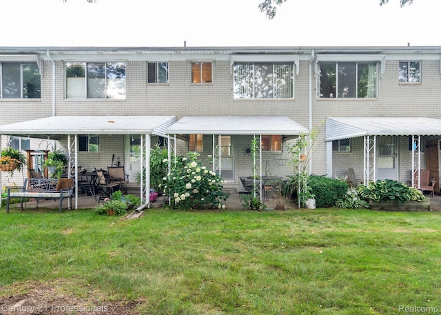 5959 Alan Dr # 56, Brighton, MI 48116 - rear view of property with a yard, brick siding, and a patio