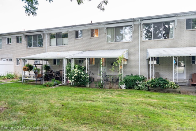 5959 Alan Dr # 56, Brighton, MI 48116 - back of house featuring a yard, brick siding, and a patio area