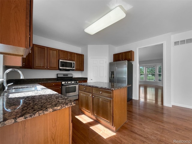 1960 Frances Way, Ypsilanti, MI 48198 - kitchen with appliances with stainless steel finishes, dark wood-style floors, dark stone countertops, and a kitchen island