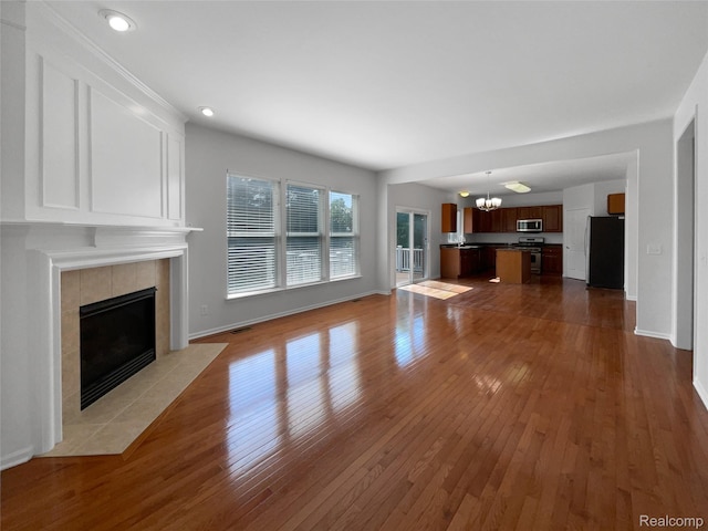 1960 Frances Way, Ypsilanti, MI 48198 - unfurnished living room featuring a tile fireplace, a chandelier, wood-type flooring, and recessed lighting