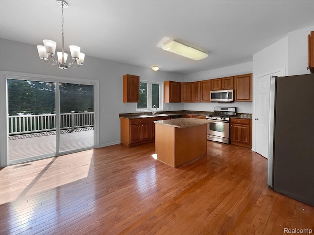 1960 Frances Way, Ypsilanti, MI 48198 - kitchen featuring stainless steel appliances, hardwood / wood-style flooring, brown cabinetry, and a kitchen island