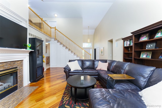 13381 Latheron Dr, Plymouth, MI 48170 - living room featuring a towering ceiling, wood finished floors, stairway, and a fireplace