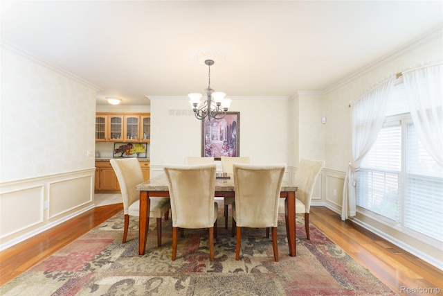 13381 Latheron Dr, Plymouth, MI 48170 - dining room featuring a chandelier, wood finished floors, a decorative wall, ornamental molding, and wainscoting