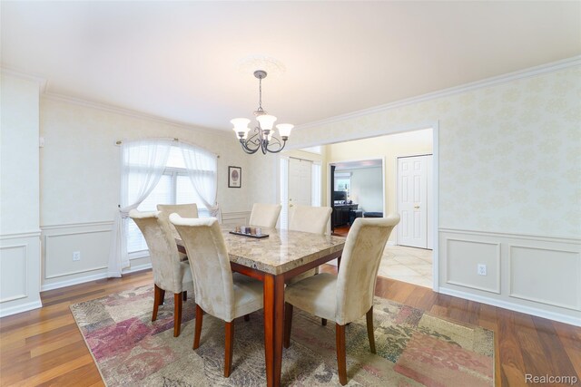 13381 Latheron Dr, Plymouth, MI 48170 - dining room featuring a chandelier, ornamental molding, a wainscoted wall, a decorative wall, and wood finished floors