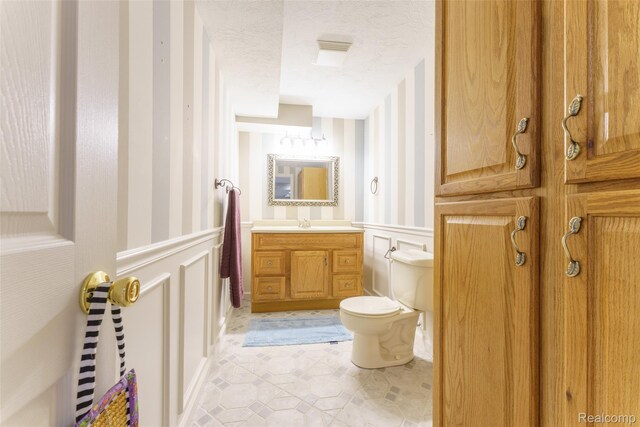 13381 Latheron Dr, Plymouth, MI 48170 - half bath with wallpapered walls, a decorative wall, a wainscoted wall, tile patterned flooring, and vanity