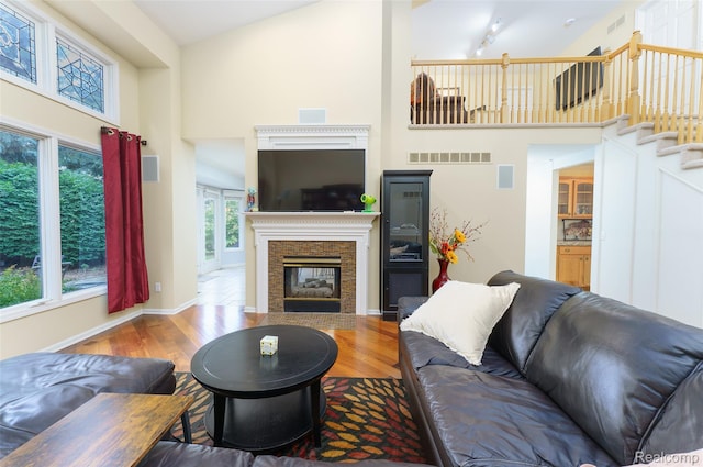 13381 Latheron Dr, Plymouth, MI 48170 - living area featuring a high ceiling, wood finished floors, a glass covered fireplace, and stairs