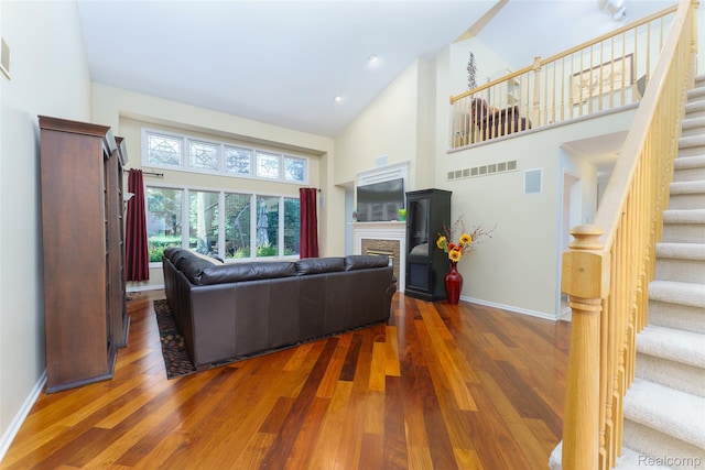 13381 Latheron Dr, Plymouth, MI 48170 - living room featuring high vaulted ceiling, stairway, wood finished floors, and a fireplace